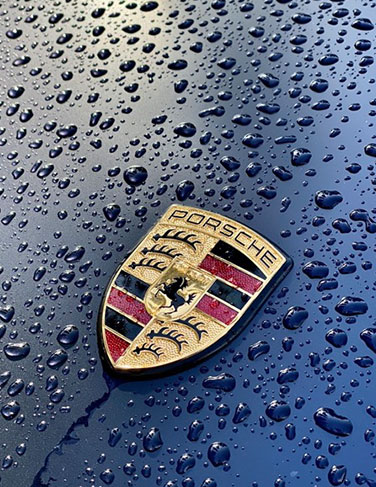 Porsche logo surrounded by water droplets